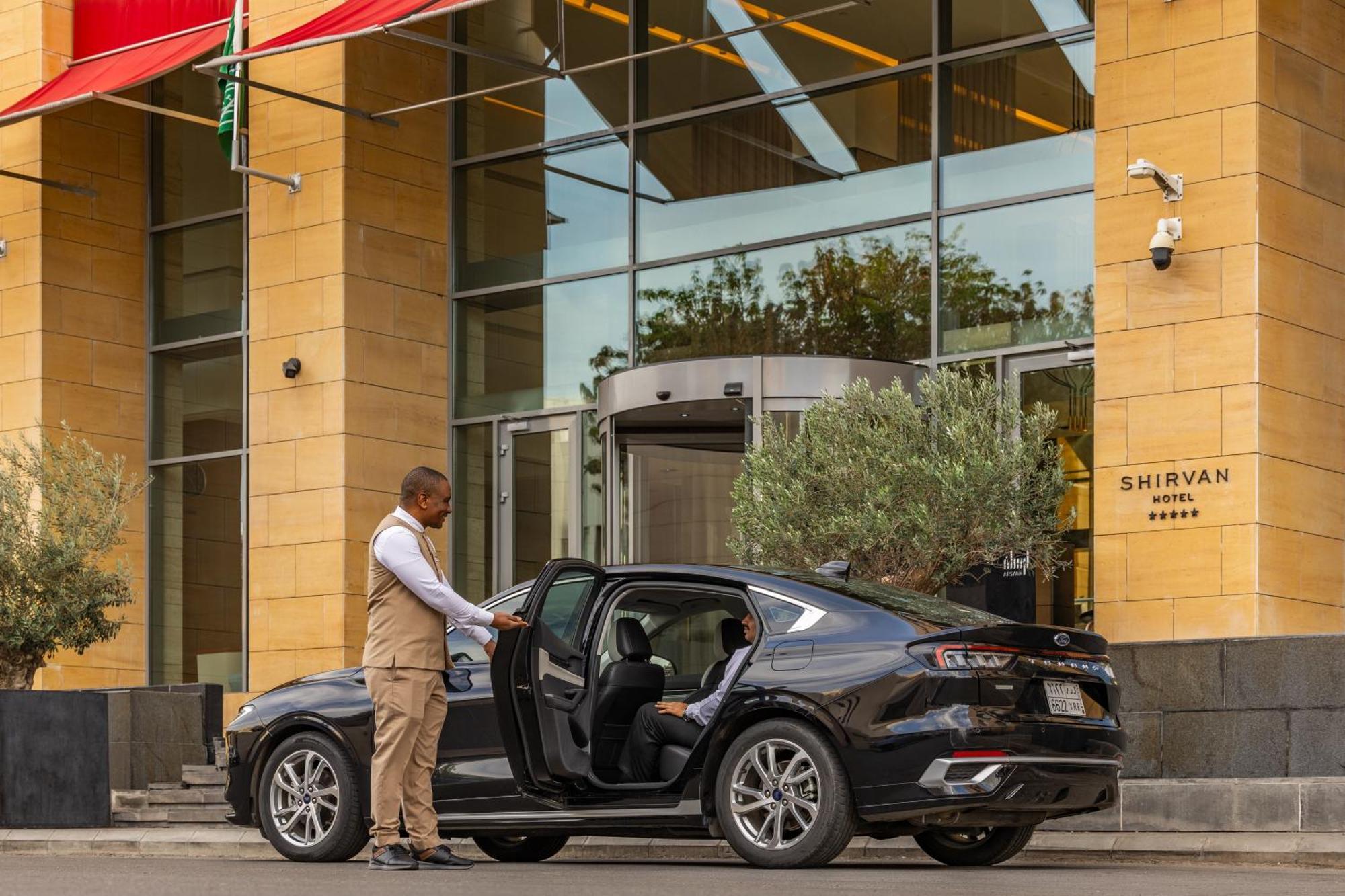 Shirvan Hotel City Yard Djedda Buitenkant foto A chauffeur opening the door of a car